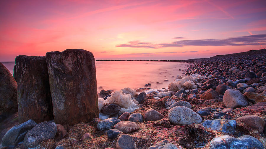 Groynes on the beach in a colorful sunset Photograph by Fhm