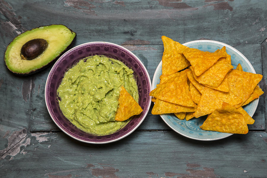 Guacamole, sliced avocado and tortilla chips Photograph by Westend61