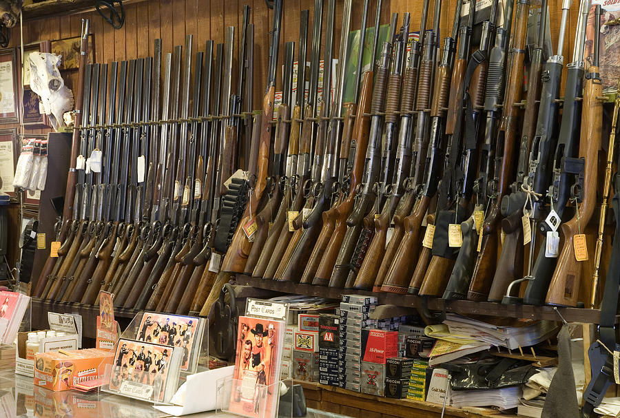Guns on rack in store, close-up Photograph by Michael Dunning
