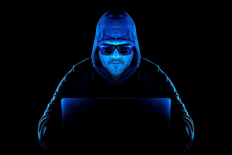 Hacker man with laptop stealing personal data from internet Photograph by 5m3photos