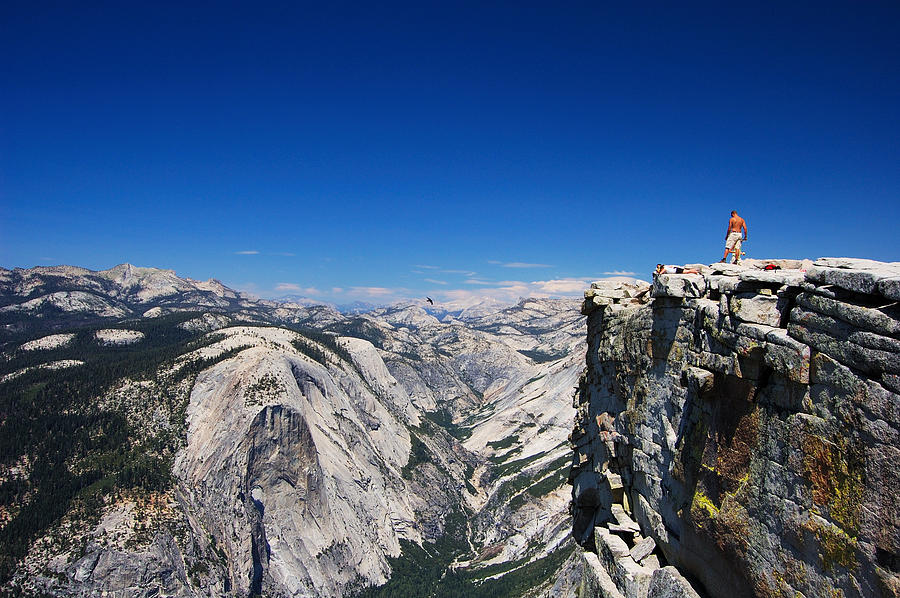 Half Dome rock with snow and person standing on the edge Photograph by Paule858