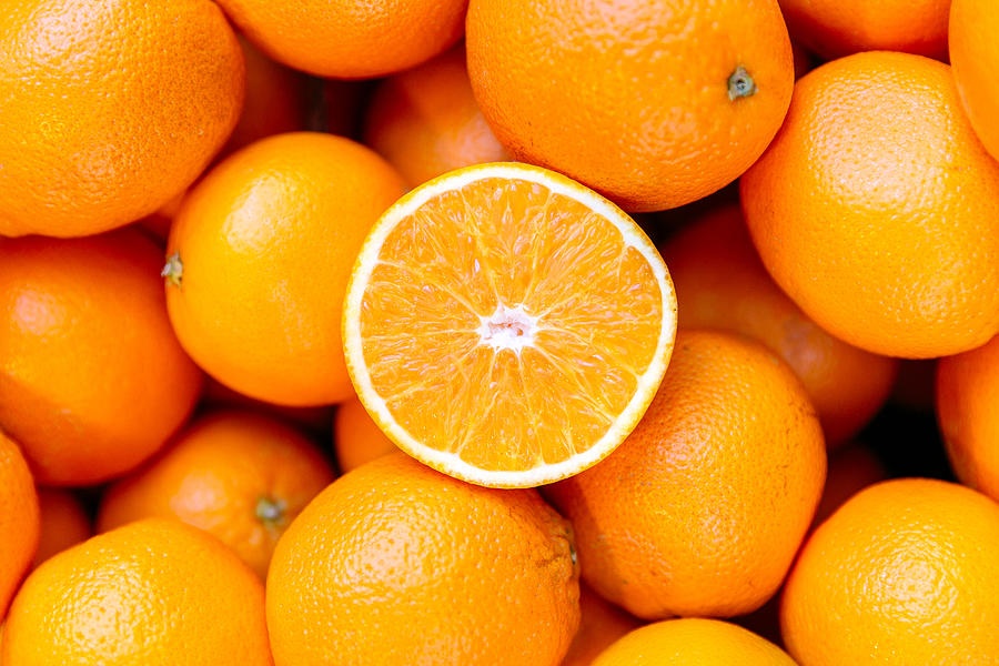 Half of orange on the heap of oranges Photograph by Alexander Spatari