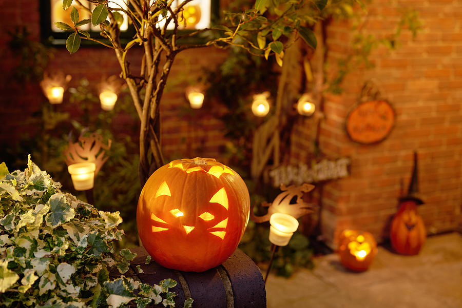 Halloween, Lit Pumpkin Outside Residential House Photograph by Peter Dazeley