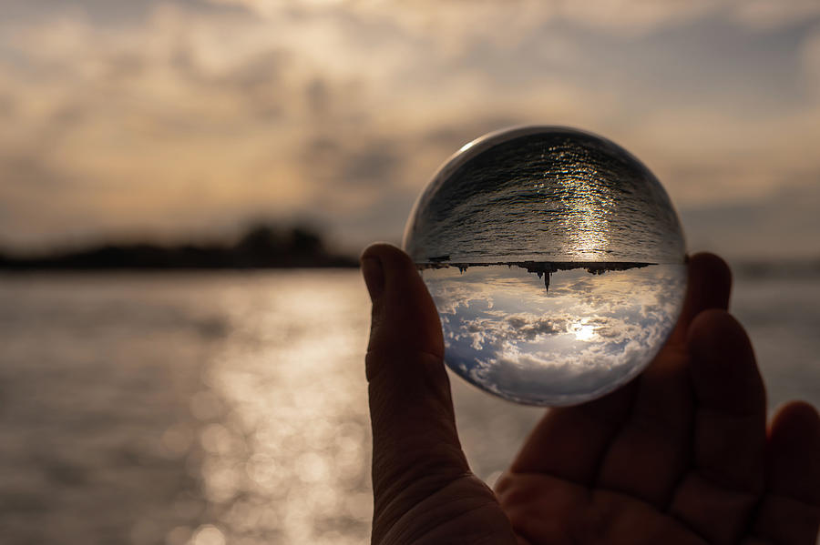 Hand holding glass sphere in front of sunset Photograph by Stefan ...