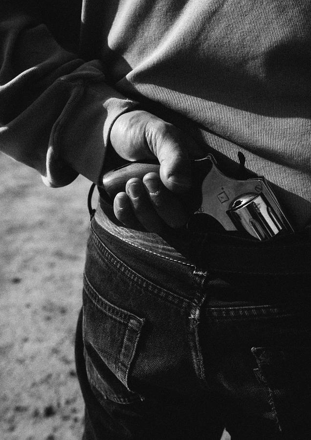 Hand holding gun, close-up, rear view, b&w Photograph by Laurent Hamels
