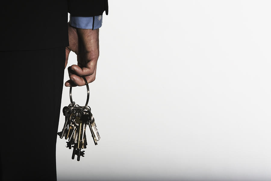 Hand holding large ring of keys Photograph by Martin Barraud