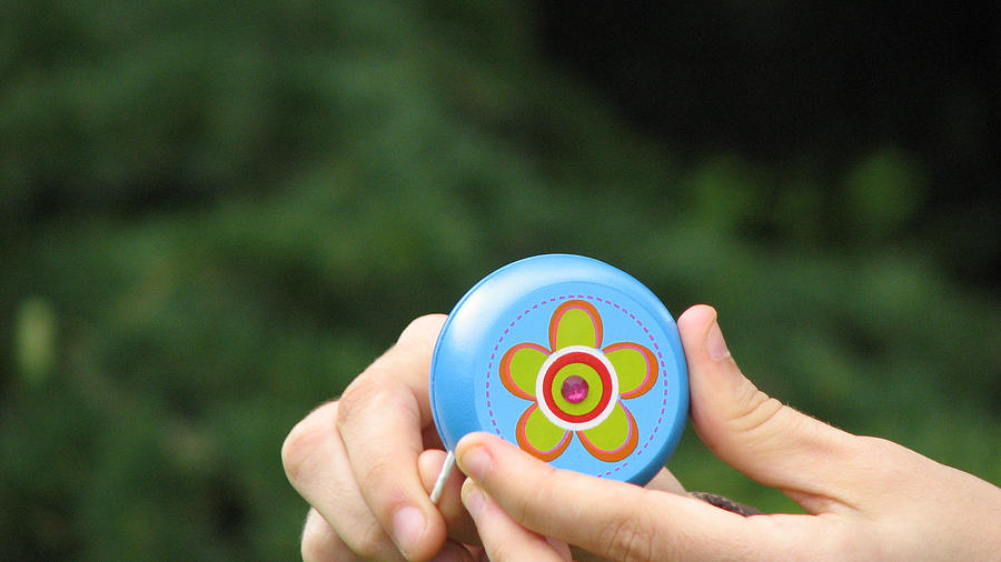 Hand holding Yo-Yo toy Photograph by Cristian Bortes
