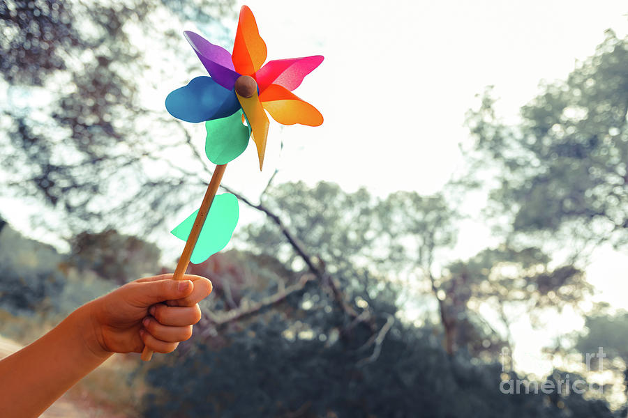 Hand holds a toy pinwheel, concept of inspiration and dreams in freedom. Photograph by Joaquin Corbalan