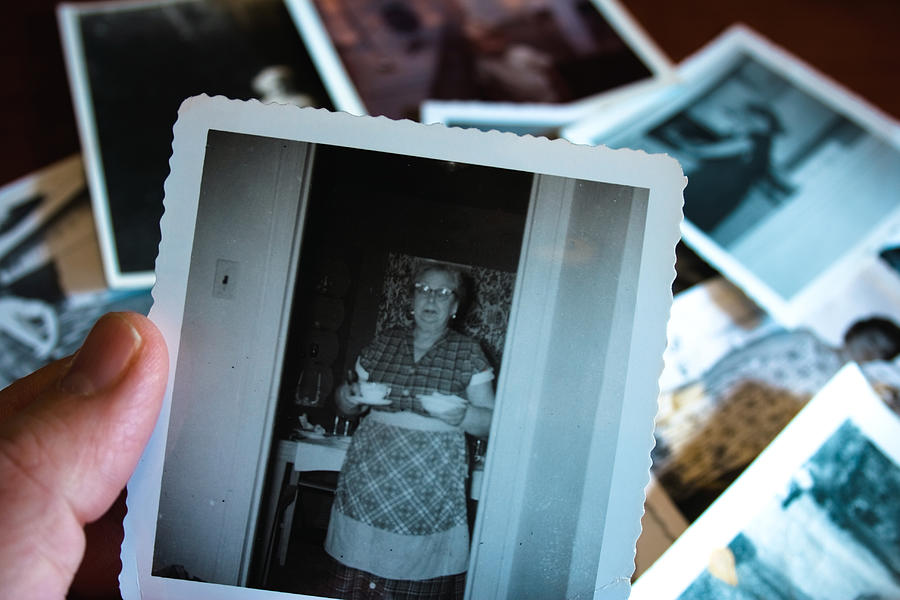 Hand holds Vintage photograph of 1950s grandma serving soup Photograph by Catscandotcom
