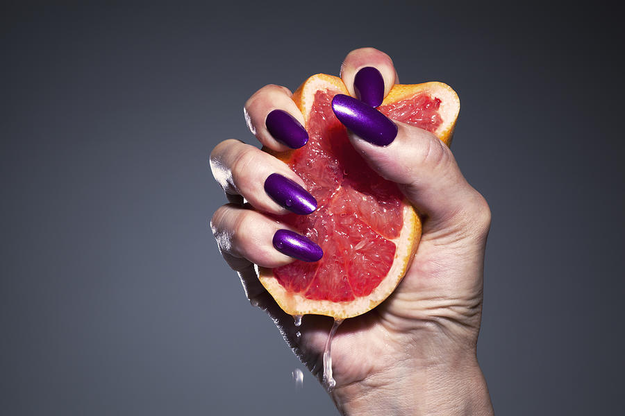 Hand of a woman crushing grapefruit Photograph by Hiroshi Watanabe