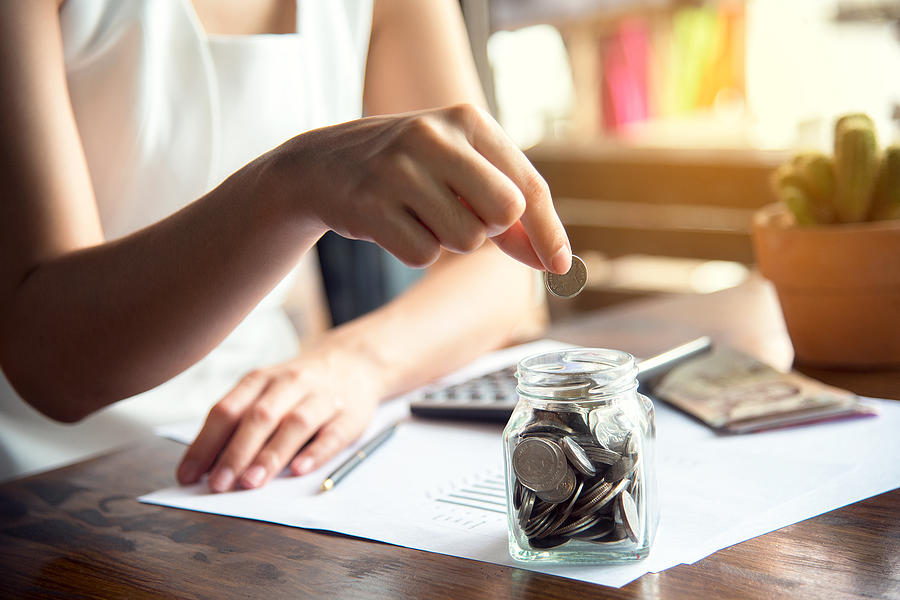 Hand of female putting coin in jar with money stack step growing growth saving money, Concept finance business investment Photograph by Abraham