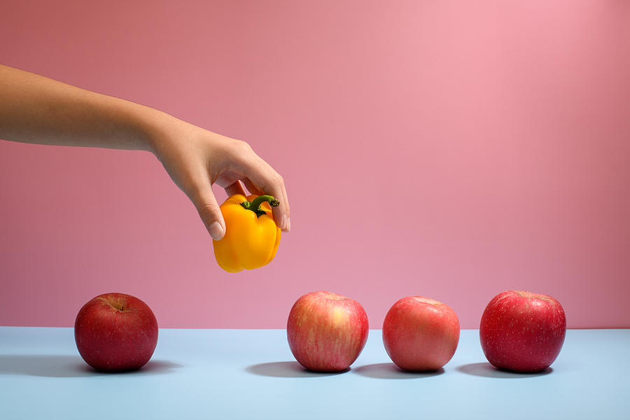 Hand Picking Apple from Row to Illustrate Choice and Decision Photograph by Jordan Lye
