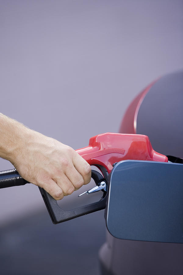 Hand pumping gas into vehicle Photograph by Comstock Images