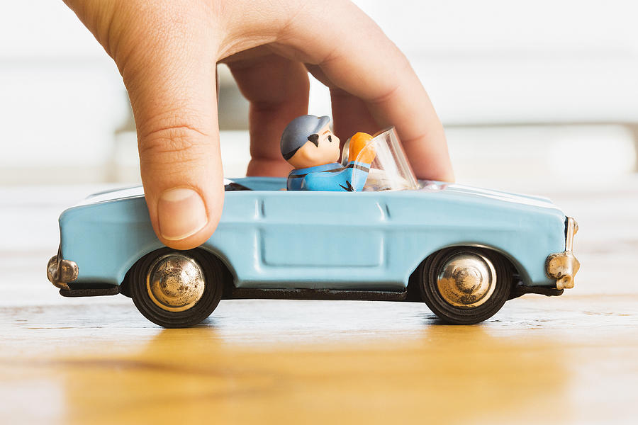 Hand pushing vintage blue toy convertible car Photograph by Dimitri Otis