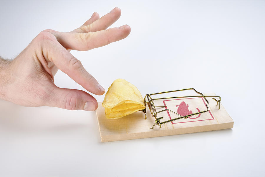 Hand reaching for potato chips on mousetrap Photograph by Berkpixels