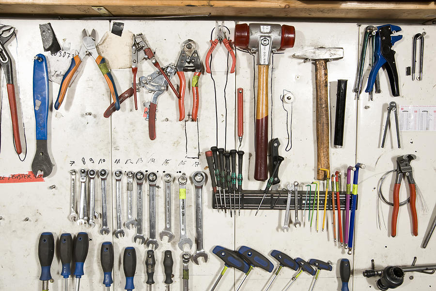 Hand tools arranged on a wall Photograph by Adam Burn
