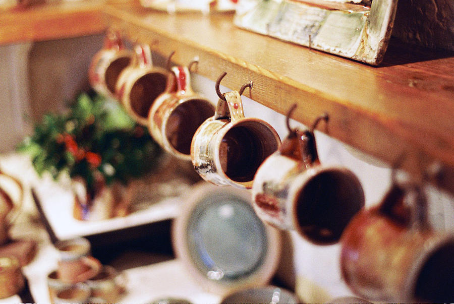 Handmade pottery mugs hanging on a shelf Photograph by Benjamin Clinch