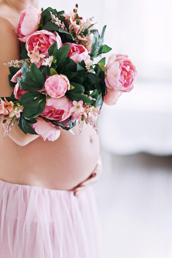 Hands and pink peony flowers on pregnant belly of a woman in a pink tender tutu skirt Photograph by With love of photography