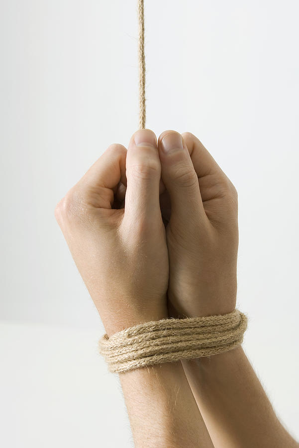 Hands bound with rope, close-up Photograph by PhotoAlto/Michele Constantini