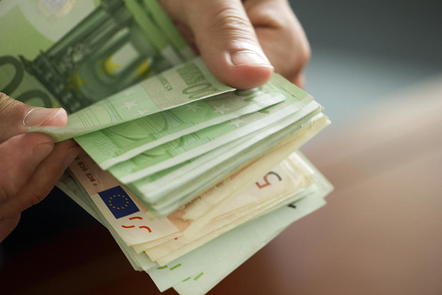 Hands countong stack of money, cropped Photograph by PhotoAlto/Frederic Cirou