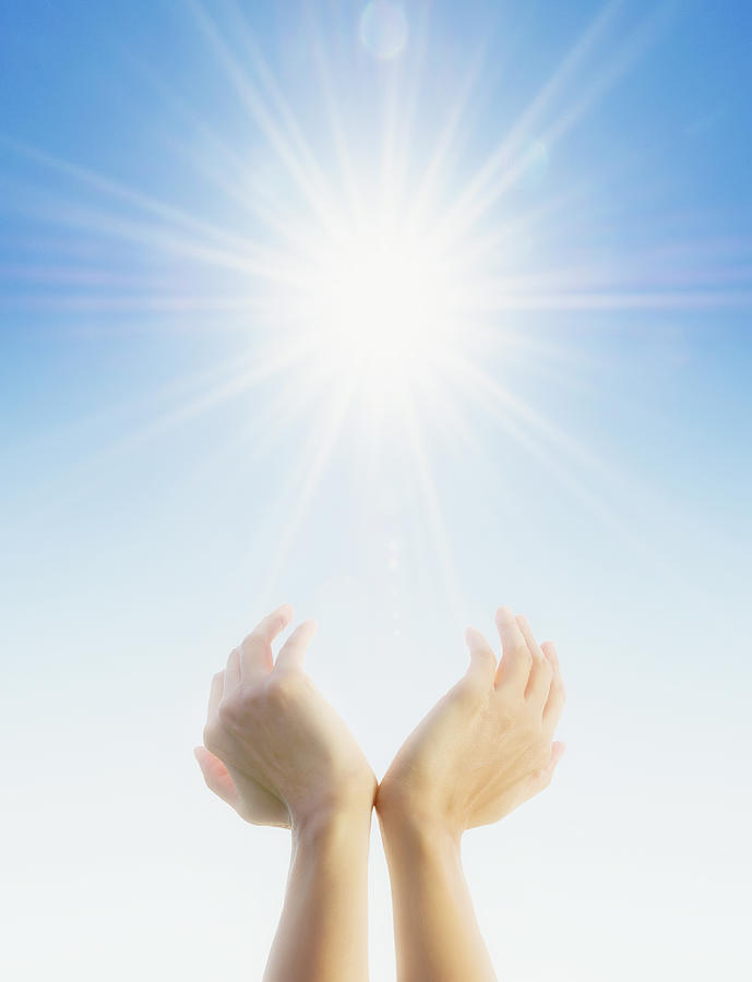 Hands cupping around sun in blue sky Photograph by Jacobs Stock Photography Ltd