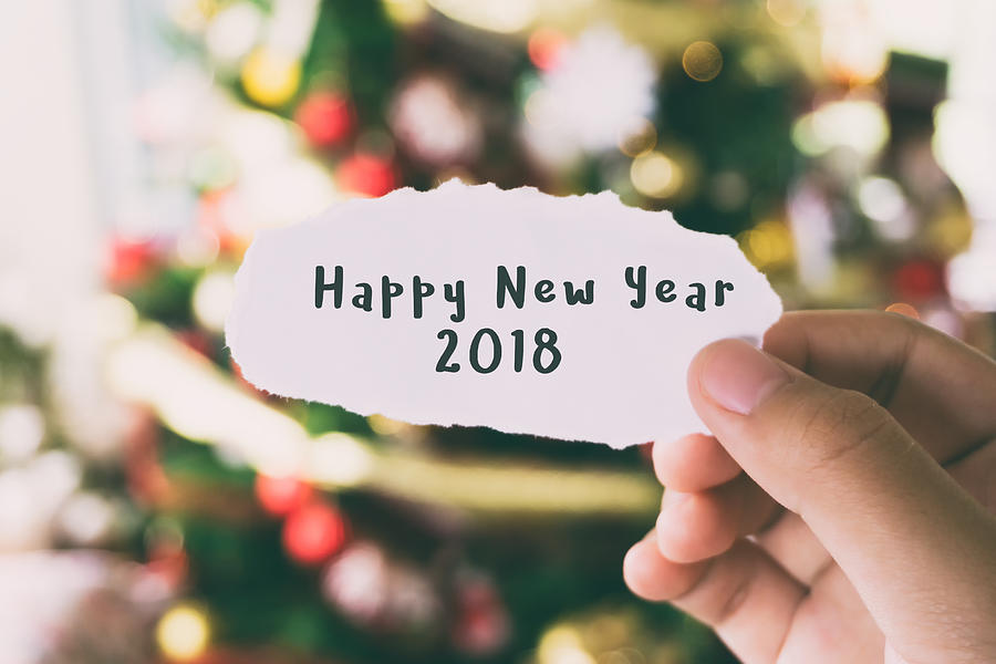 Hands Holding Piece of Paper With Word Happy New Year 2018 Christmas Tree Background Photograph by Nora Carol Photography