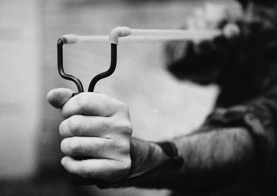 Hands holding sling shot, close-up, b&w Photograph by Laurent Hamels