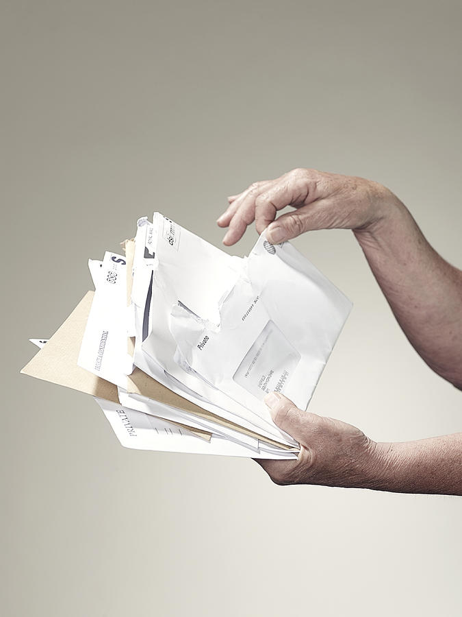 Hands holding stack of letters and bills Photograph by John Scott