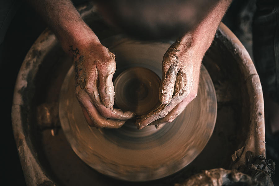 Hands of master in process of work in pottery / ceramic workshop. Small business concept. Photograph by Olga Pankova