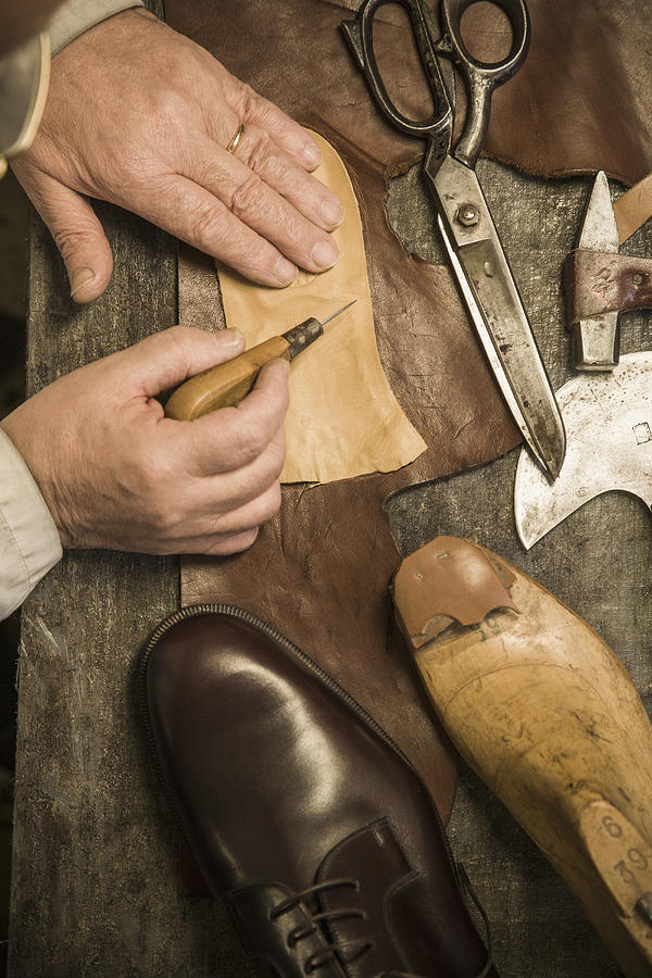 Hands of shoemaker using awl on leather Photograph by Terry Vine