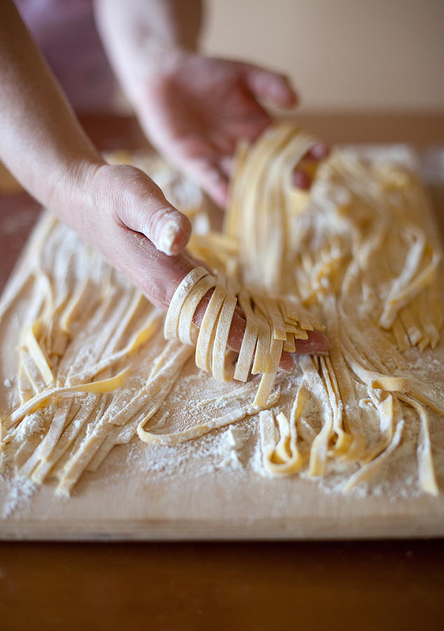 Hands of woman sorting some tagliatelle Photograph by Nico De Pasquale Photography