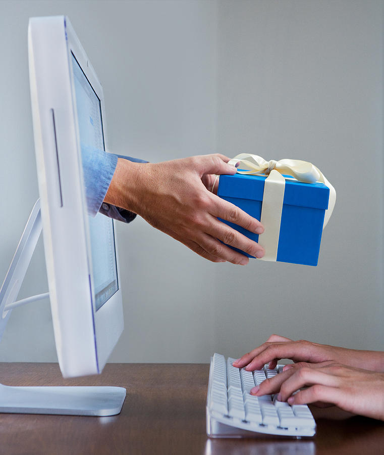 Hands typing on keyboard while a gift appears from a computer screen Photograph by David Malan