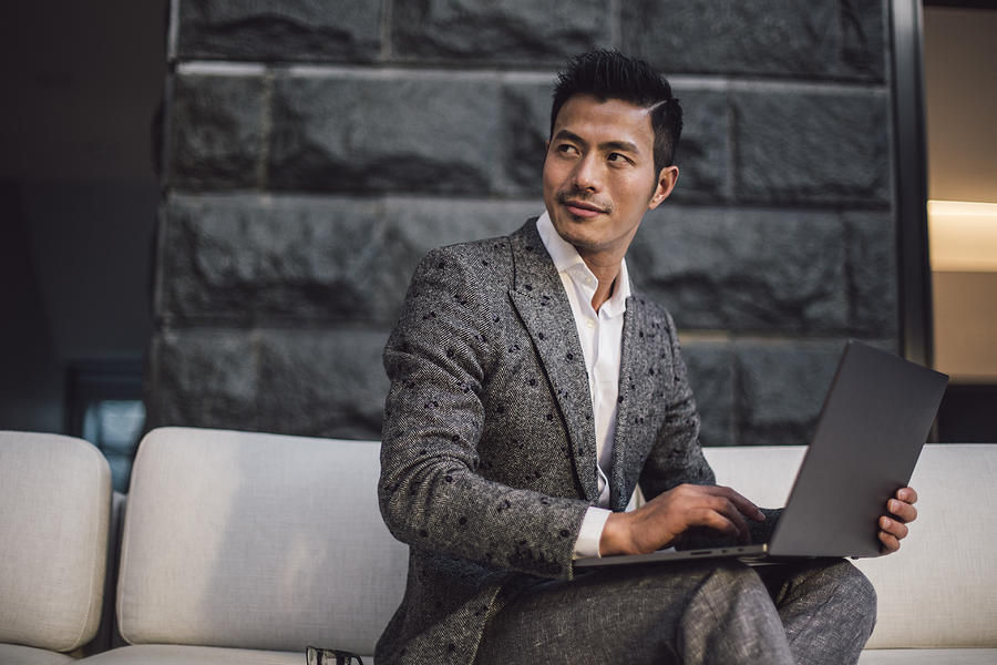Handsome businessman using laptop Photograph by South_agency