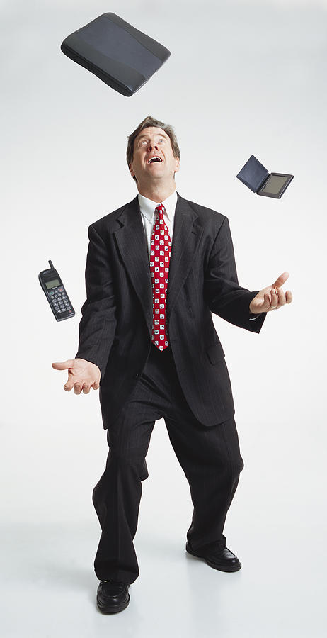 Handsome Middle Aged Caucasian Businessman Dark Suit Juggles Laptop Computer Palm Pilot Cell Phone Photograph by Photodisc