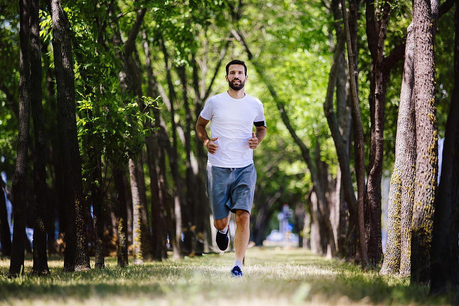 Handsome young man running in nature Photograph by Milanvirijevic
