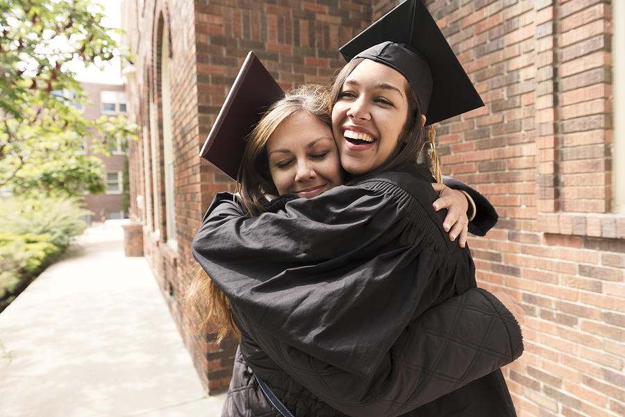 Happy American Mother Hugs Daughter Celebrating Graduation Day USA Photograph by Lorraine Boogich