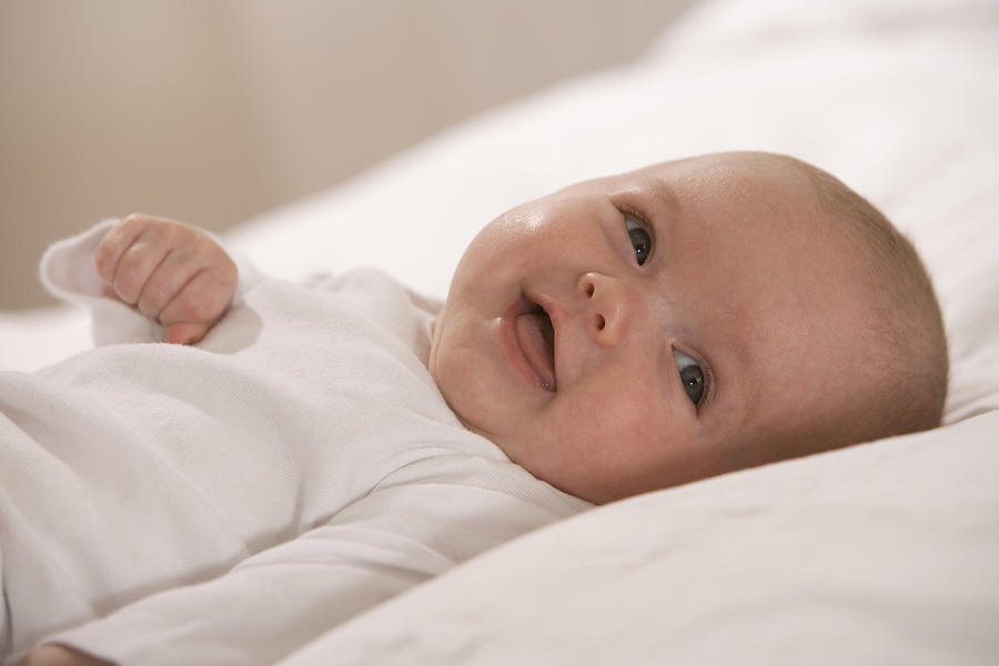 Happy baby lying down Photograph by Comstock Images