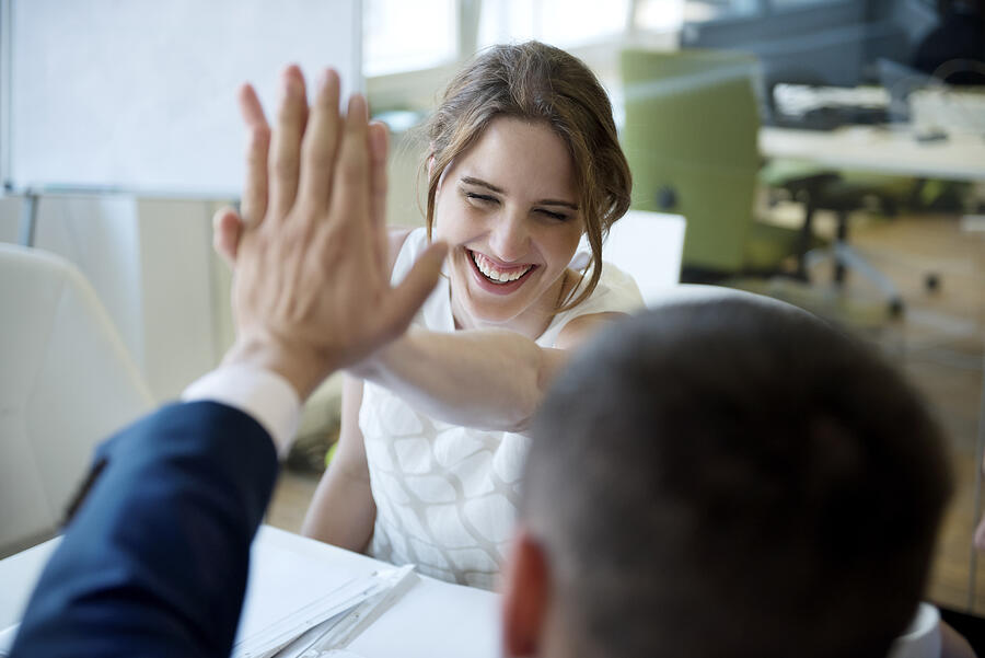 Happy businesswoman and businessman high fiving Photograph by Westend61