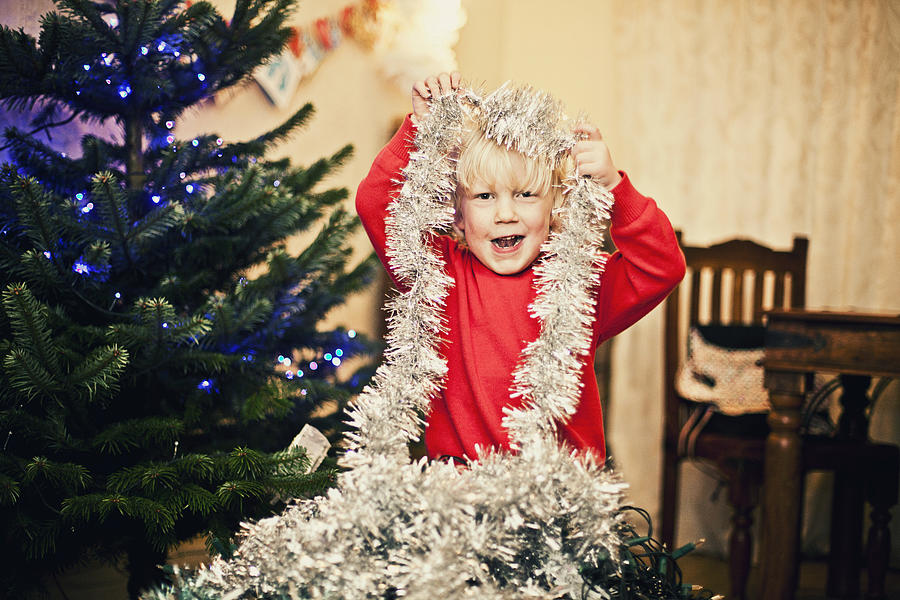 Happy child decorating the Christmas tree Photograph by Sally Anscombe