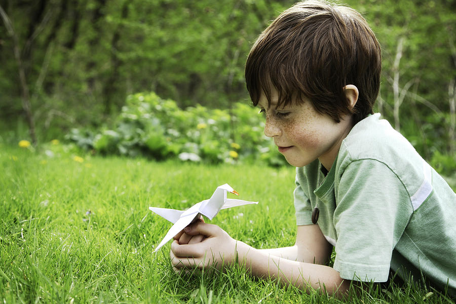 Happy Child Holding a Origami Peace Crane Outside in Nature Photograph by ParkerDeen