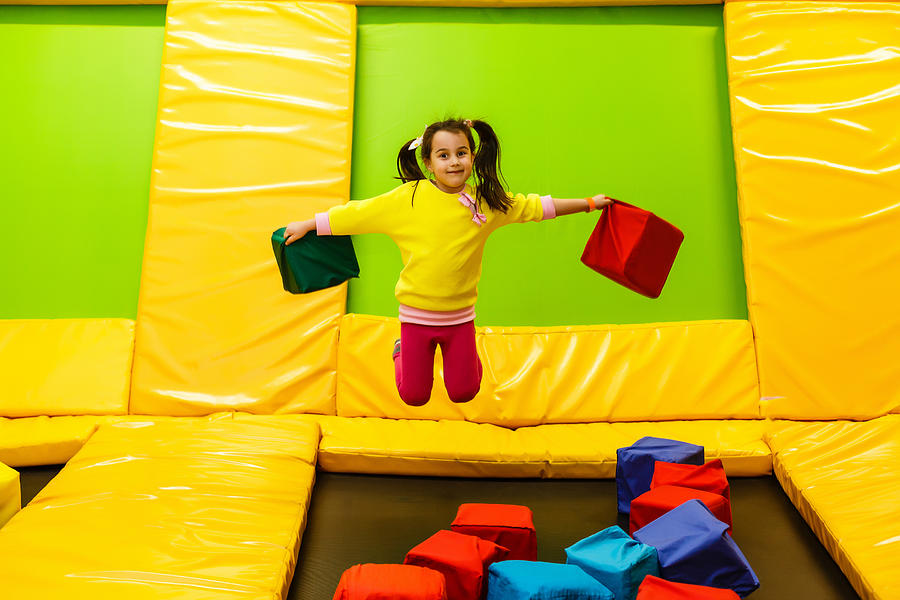 Happy Childhood Of A Modern Child In The City - Girl Jumping In The Trampoline Park Photograph by Sinenkiy