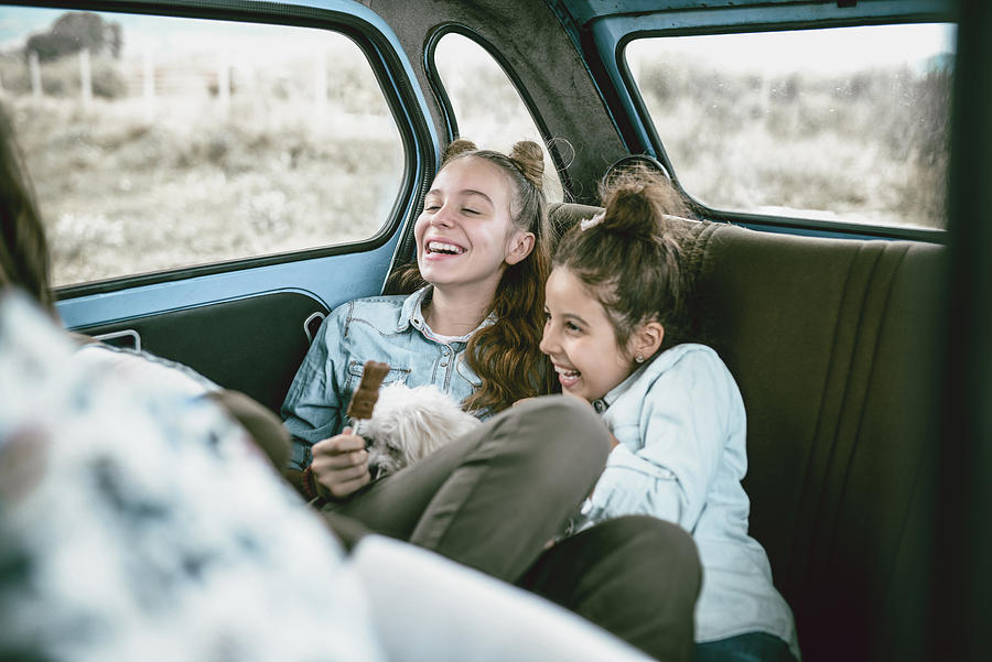 Happy Children Playing With Puppy And Eating Chocolate In The Back Of Car Photograph by AleksandarGeorgiev
