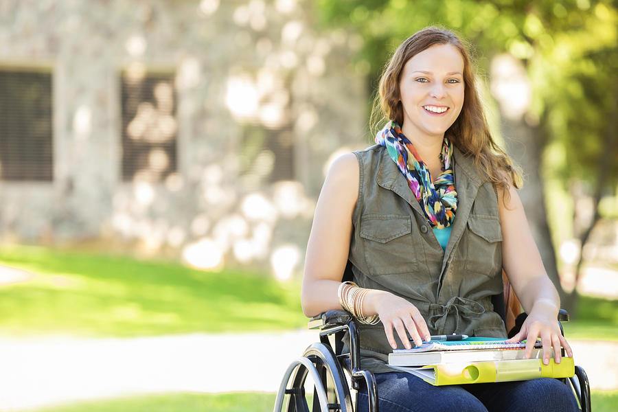 Happy college girl in wheelchair on campus Photograph by SDI Productions