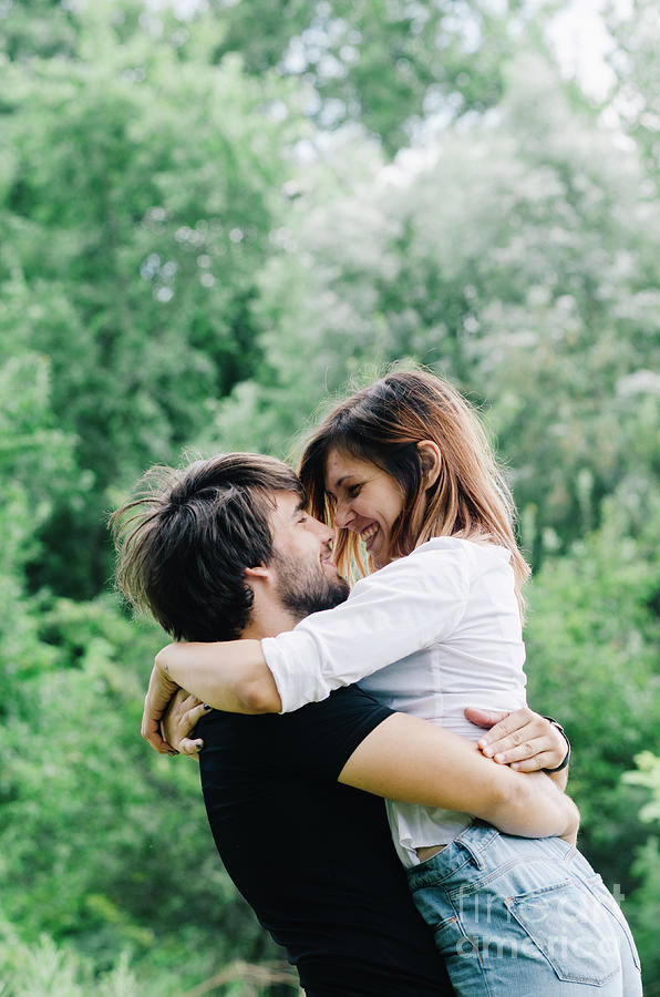 Happy couple kissing and hugging in nature. Young man and woman  Photograph by Jelena Jovanovic