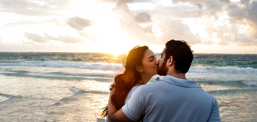 Happy couple kissing on beach. Photograph by Gary John Norman