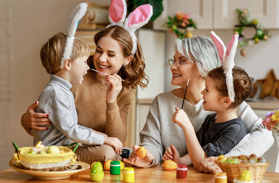 Happy easter! family mother, grandmother and children paint eggs for holiday Photograph by Evgenyatamanenko