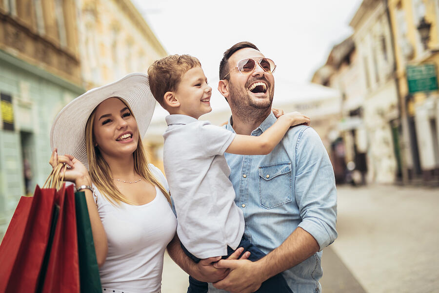 Happy family having fun outdoor after shopping Photograph by Jovanmandic