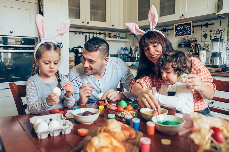 Happy family painting Easter eggs Photograph by VioletaStoimenova