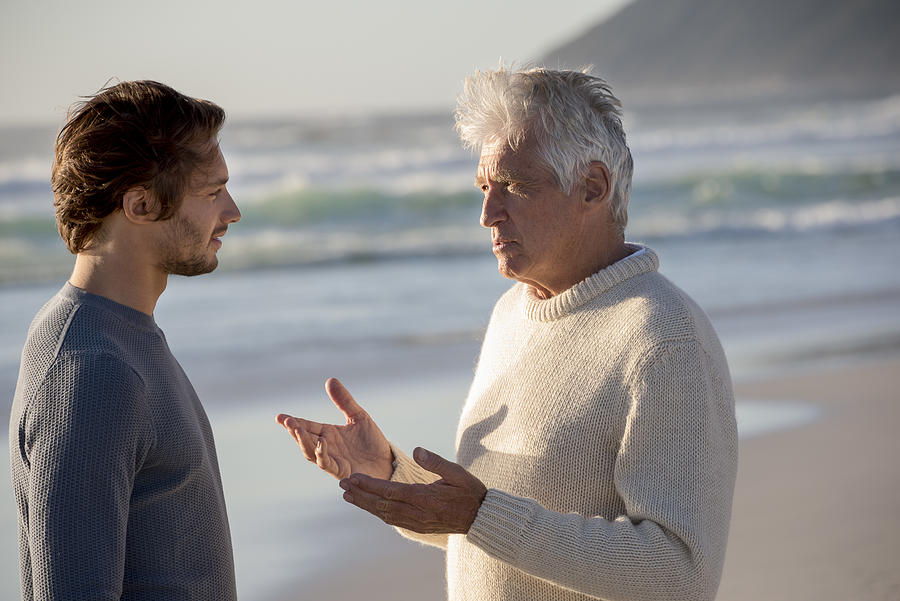 Happy father and son talking on the beach Photograph by Eric Audras