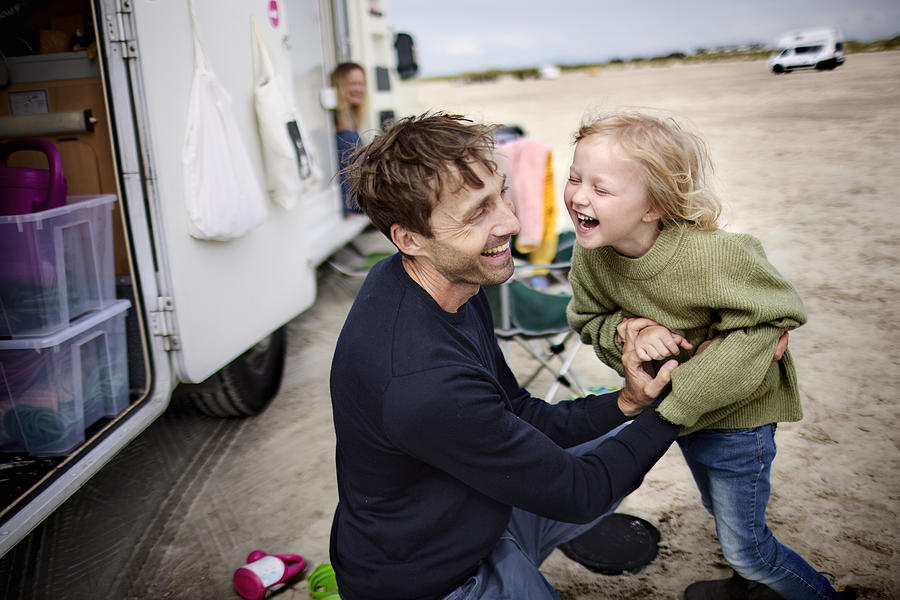 Happy father with girl at camper van on the beach Photograph by Oliver Rossi